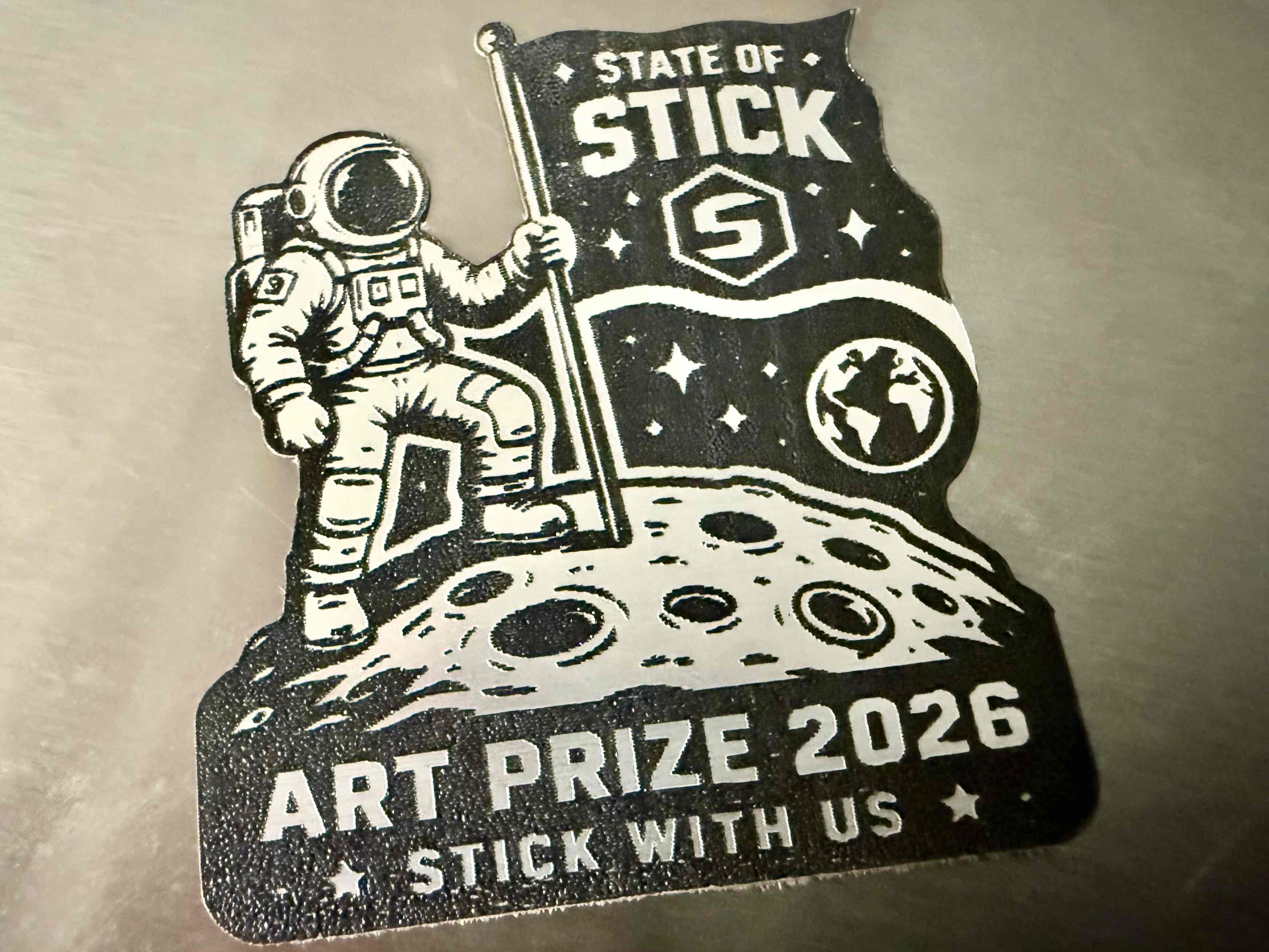 Astronaut planting a State of Stick flag on a lunar ArtPrize 2026 emblem.