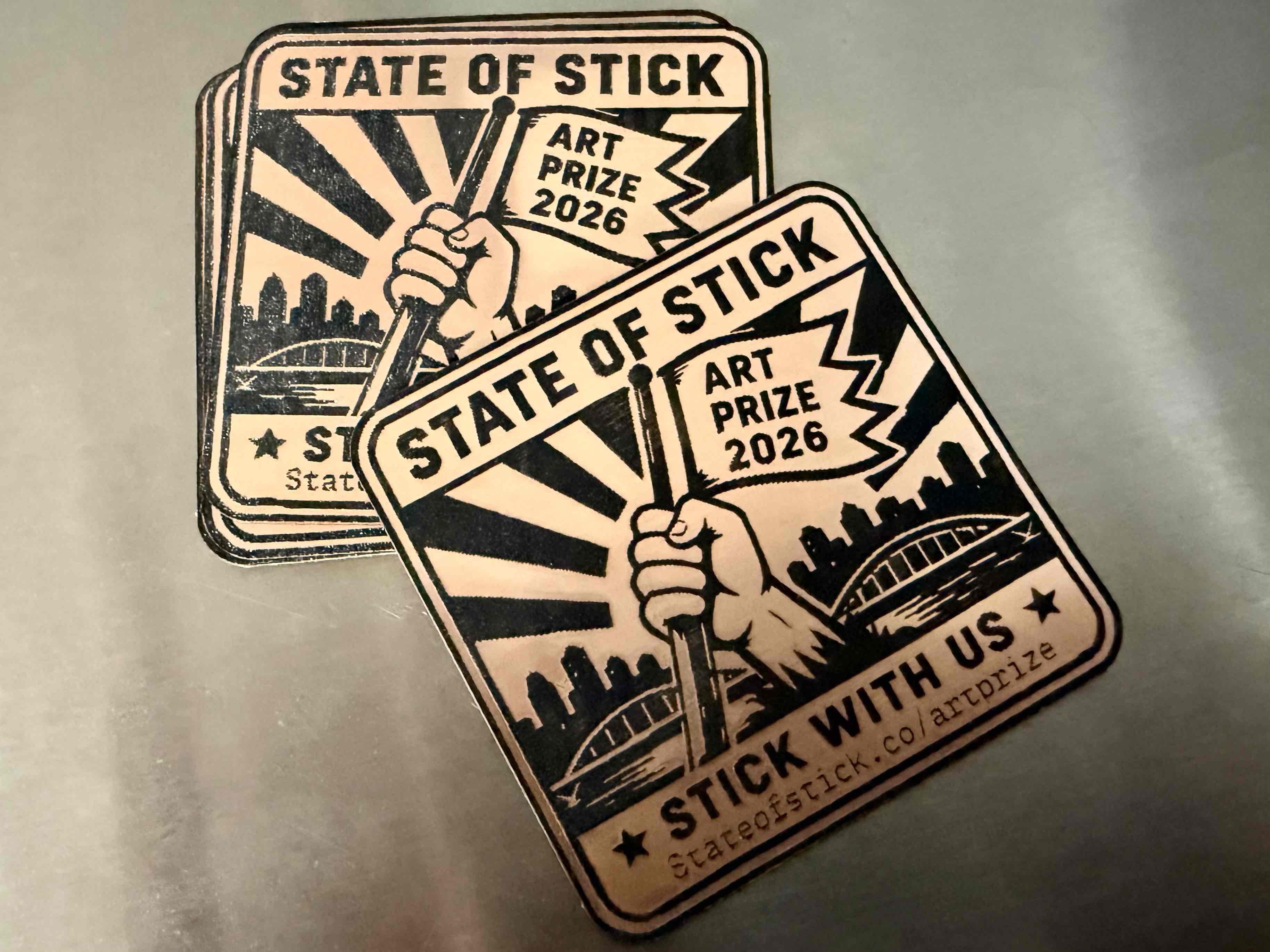 Two recently cut State of Stick ArtPrize 2026 sign-shaped emblems.