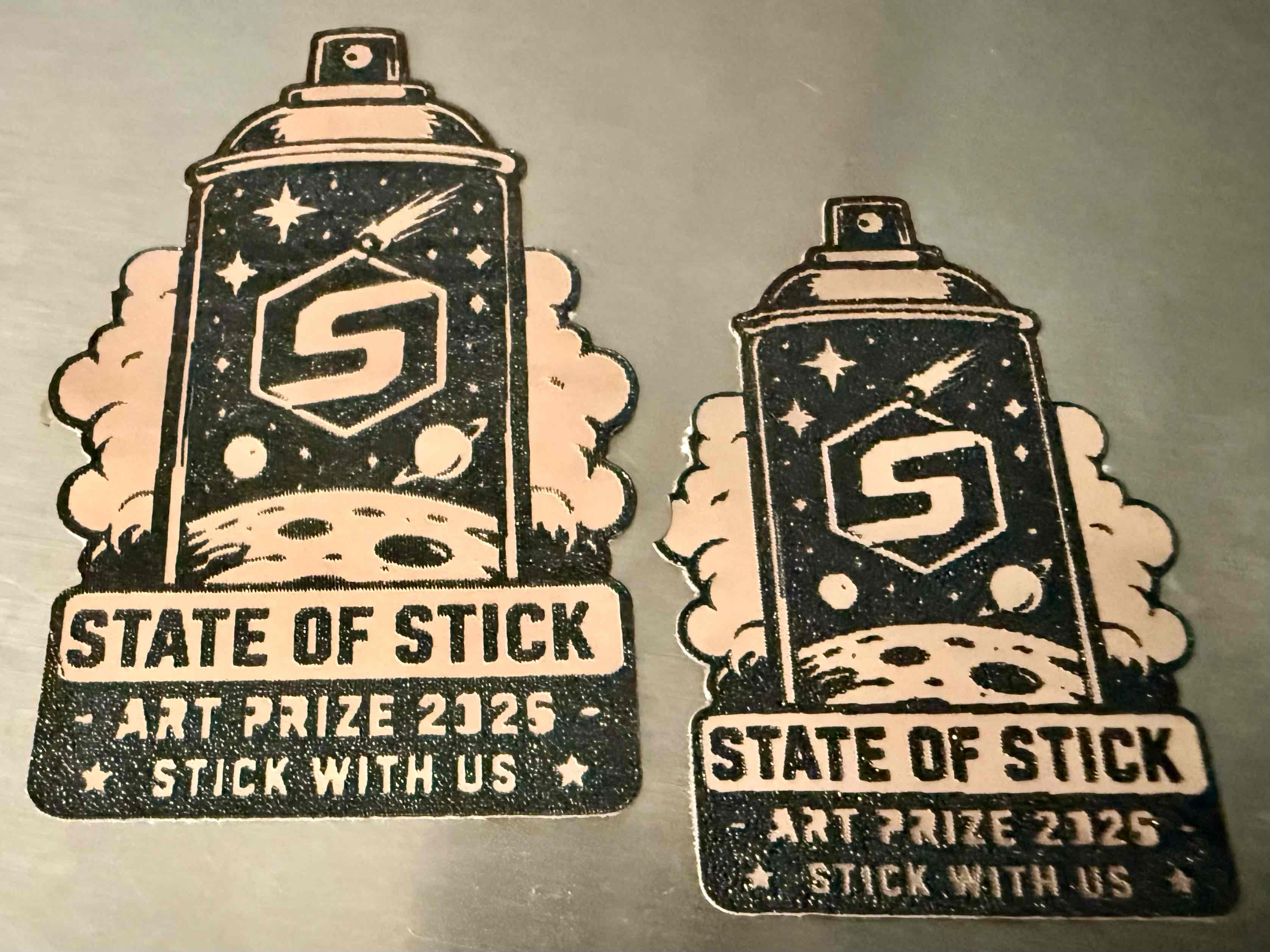 Two space-themed spray-can State of Stick emblems.