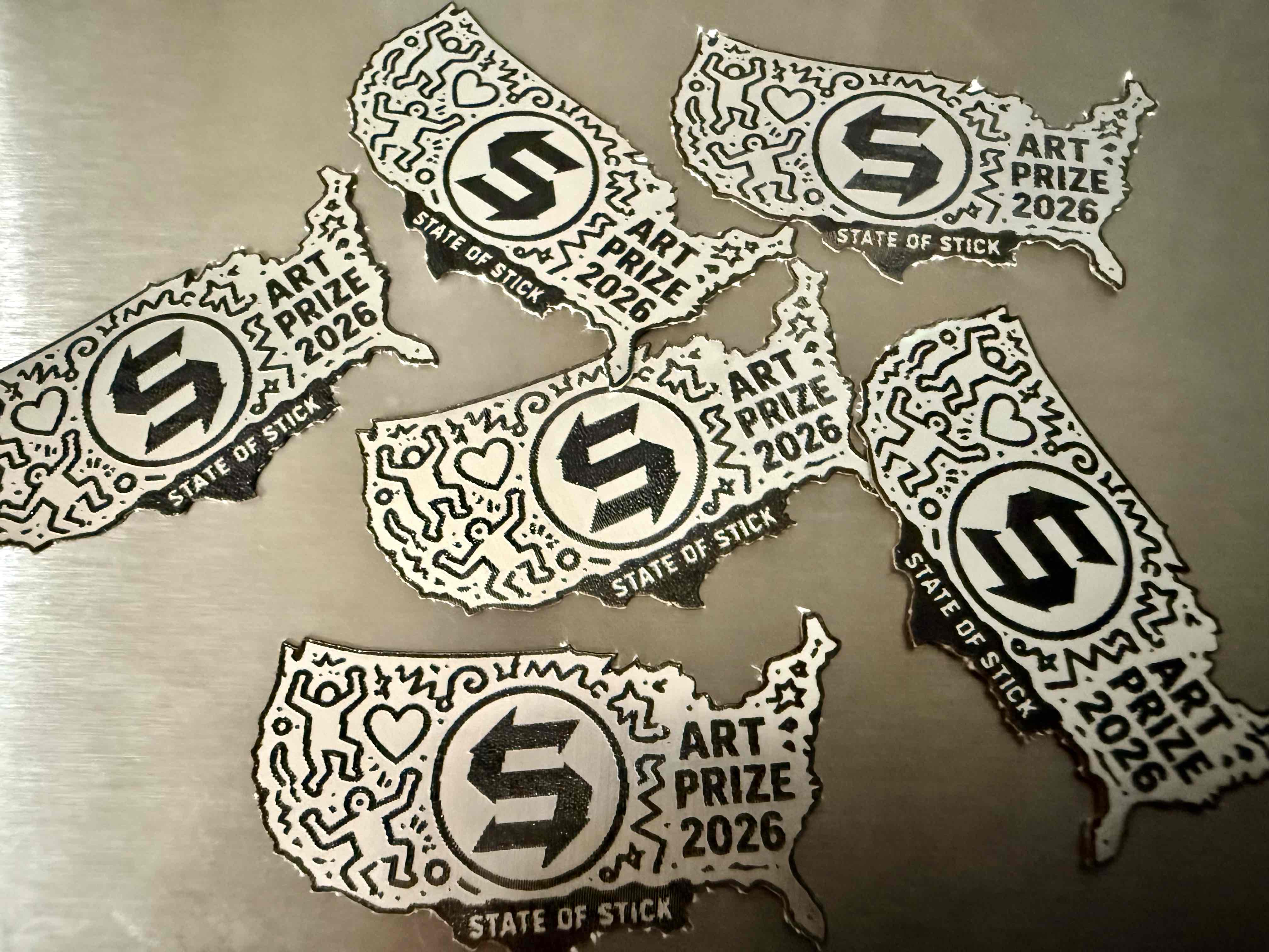A group of United States-shaped ArtPrize 2026 emblems.